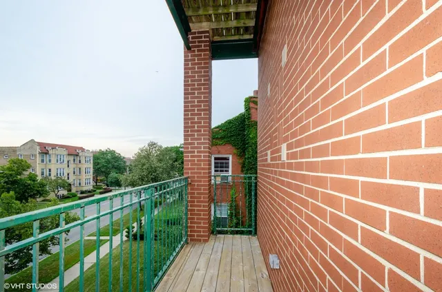 a view of a balcony with wooden floor and fence