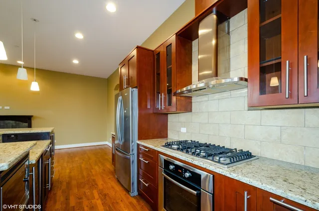 a kitchen with stainless steel appliances granite countertop a stove a sink and a refrigerator