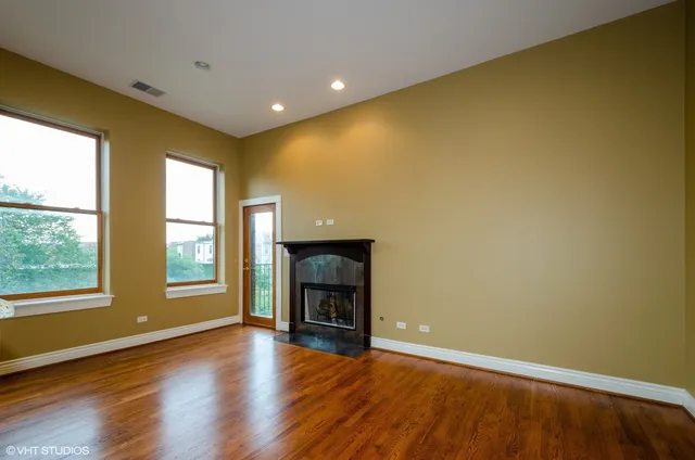 a view of an empty room with a fireplace and a window