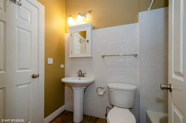 a bathroom with a sink toilet and mirror