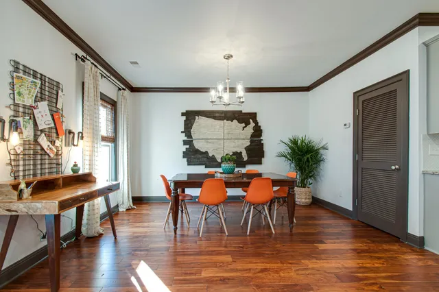 a dining room with furniture a chandelier and wooden floor