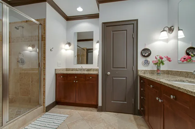 a bathroom with a granite countertop sink a mirror and a shower