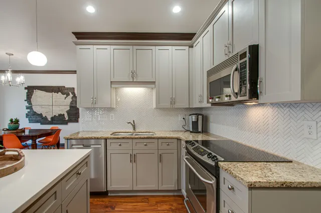 a kitchen with stainless steel appliances granite countertop a sink stove and microwave