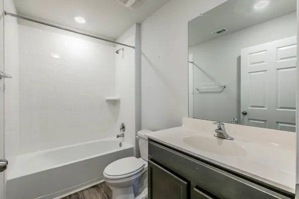 a bathroom with a sink a toilet and a mirror