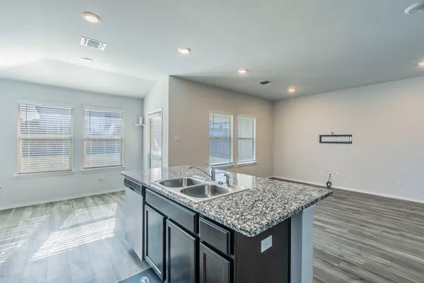 a kitchen with granite countertop sink stove and cabinets