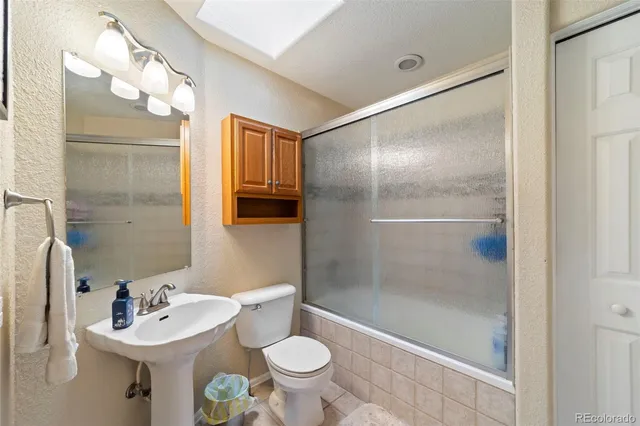 a bathroom with a sink toilet a mirror and shower