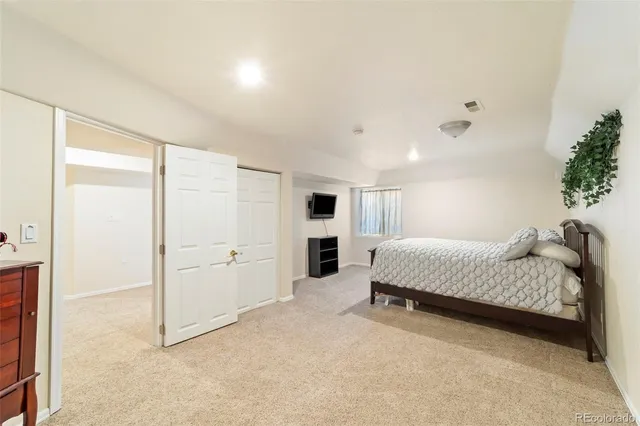 a spacious bedroom with a bed and a cabinets
