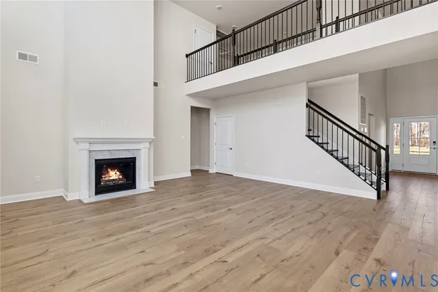 a view of a livingroom with wooden floor a fireplace and entryway