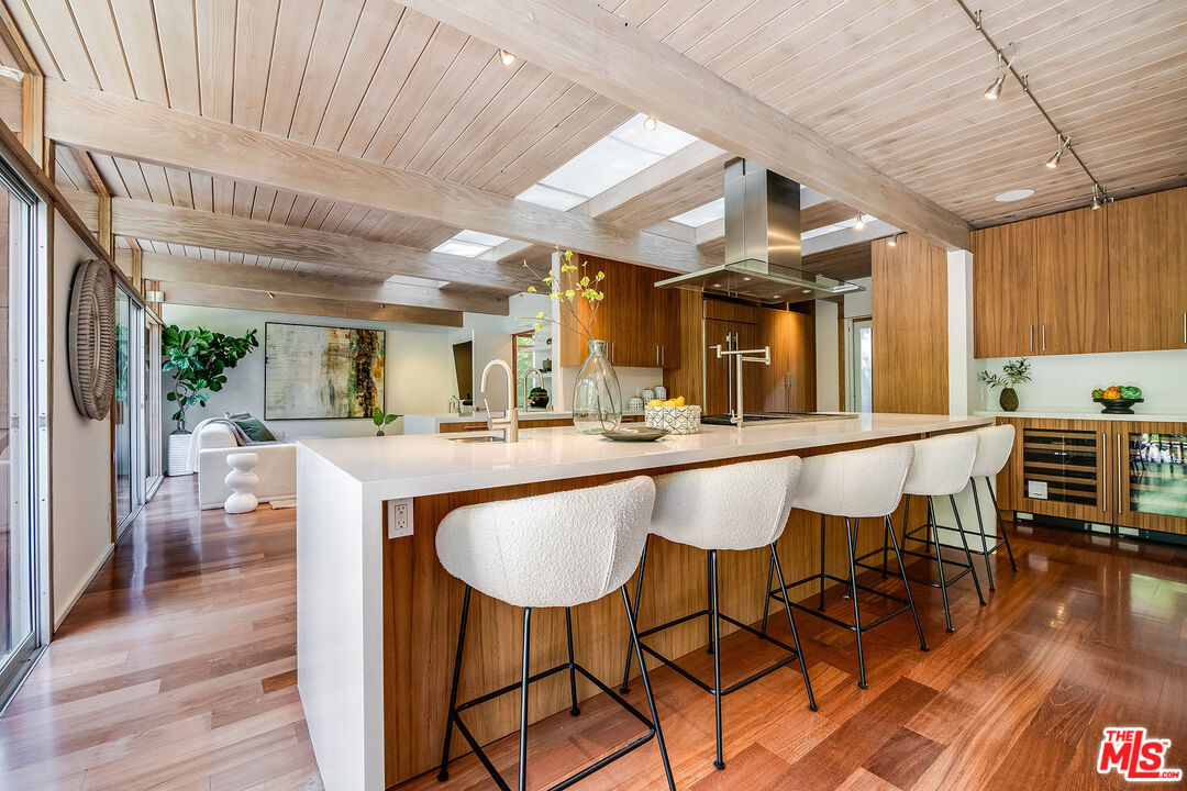 681 Brooktree Road Santa Monica, CA 90402 - Photo 14 of 32 a dining hall with stainless steel appliances kitchen island granite countertop a table chairs and a large window