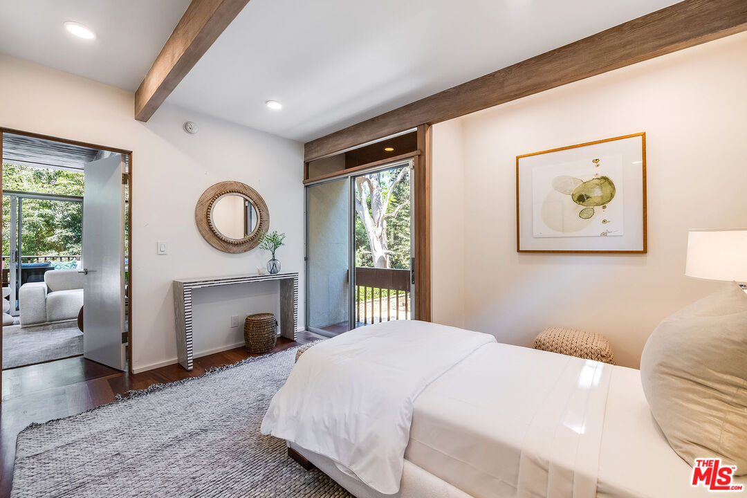 681 Brooktree Road Santa Monica, CA 90402 - Photo 19 of 32 a bedroom with a bed mirror table and a window