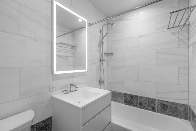 a bathroom with a sink toilet vanity and shower