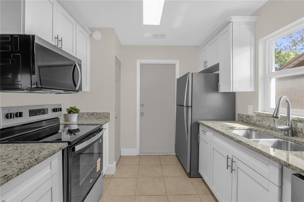 3324 Fox Ridge Drive Winter Haven, FL 33884 - Photo 11 of 28 a kitchen with stainless steel appliances granite countertop a sink stove and refrigerator