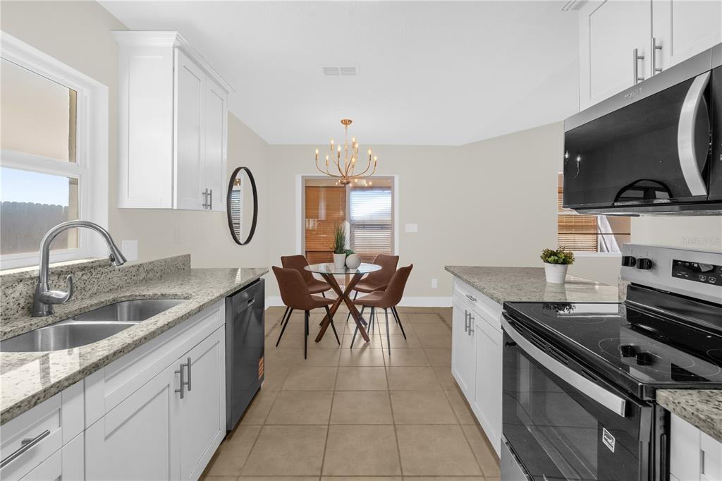 3324 Fox Ridge Drive Winter Haven, FL 33884 - Photo 12 of 28 a kitchen with granite countertop a sink a stove and cabinets