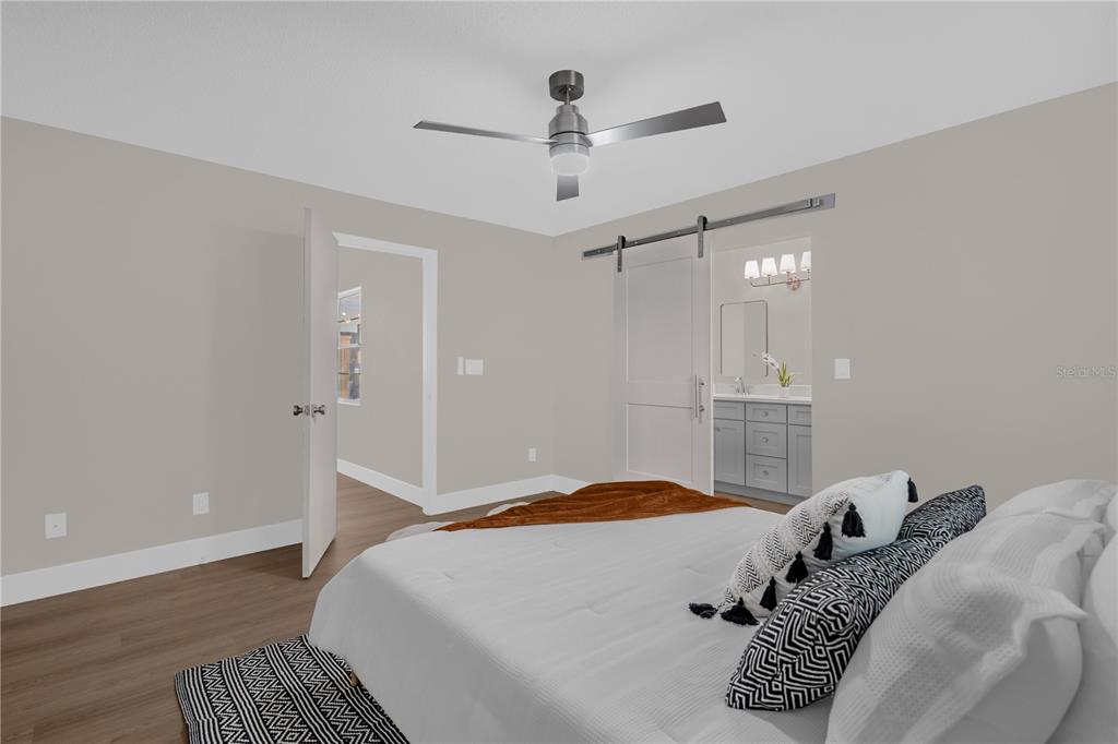 3324 Fox Ridge Drive Winter Haven, FL 33884 - Photo 18 of 28 a bedroom with a large bed and a chandelier