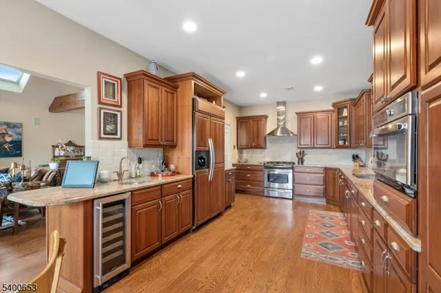 a kitchen with stainless steel appliances kitchen island granite countertop a stove refrigerator and cabinets