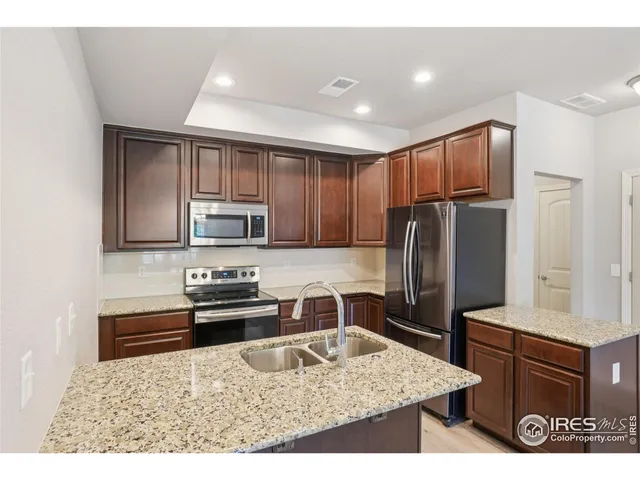 a kitchen with stainless steel appliances granite countertop a refrigerator stove microwave and sink