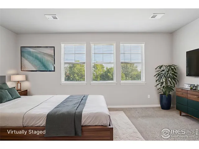 a bedroom with a bed and a large window