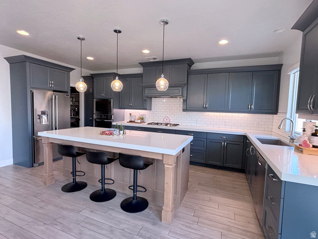 429 East Treasure Road Washington, UT 84780 - Photo 16 of 36 Kitchen with a kitchen bar, a center island, stainless steel appliances, pendant lighting, and tasteful backsplash