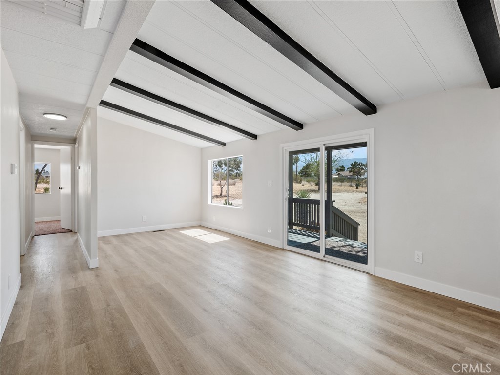 11669 Sahara Road Phelan, CA 92371 - Photo 4 of 34 a view of an empty room with wooden floor and a window