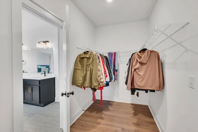 a view of walk in closet with clothes and shoes