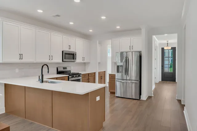 a kitchen with a refrigerator cabinets and wooden floor