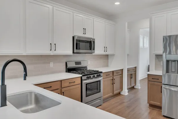 a kitchen with white cabinets and stainless steel appliances