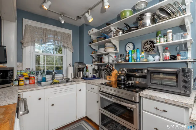a kitchen with granite countertop a stove and a wooden floor