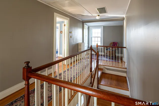 a view of a hallway with wooden floor and entryway