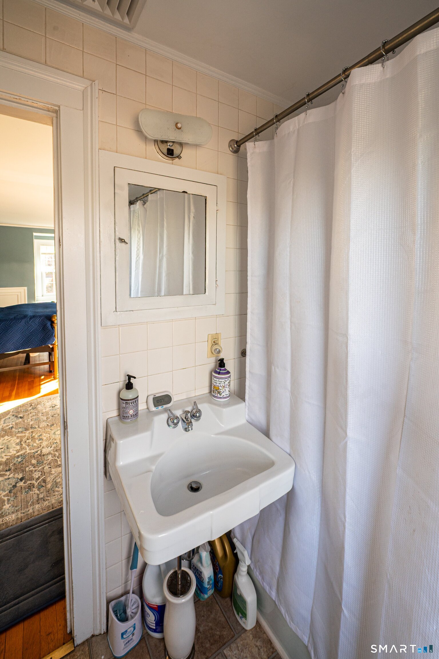 570 North Main Street Wallingford, CT 06492 - Photo 28 of 40 a bathroom with a sink a mirror and a shower curtain