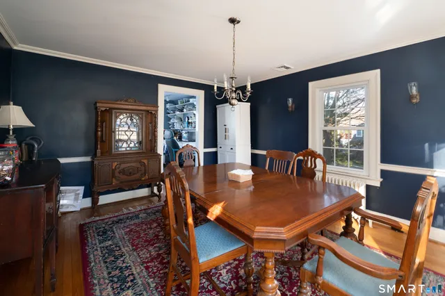 a dining room with furniture window and wooden floor