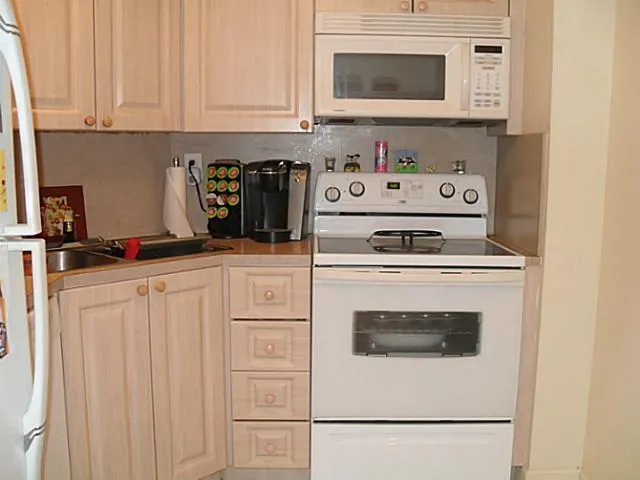 a kitchen with white cabinets and white appliances