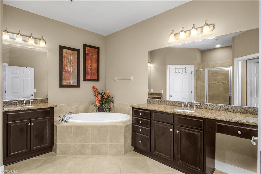 9064 Siesta Bay Drive, Unit 5102 Naples, FL 34120 - Photo 19 of 46 Spa-like primary bath features dual sinks and vanities, soaking tub, and walk-in shower.
