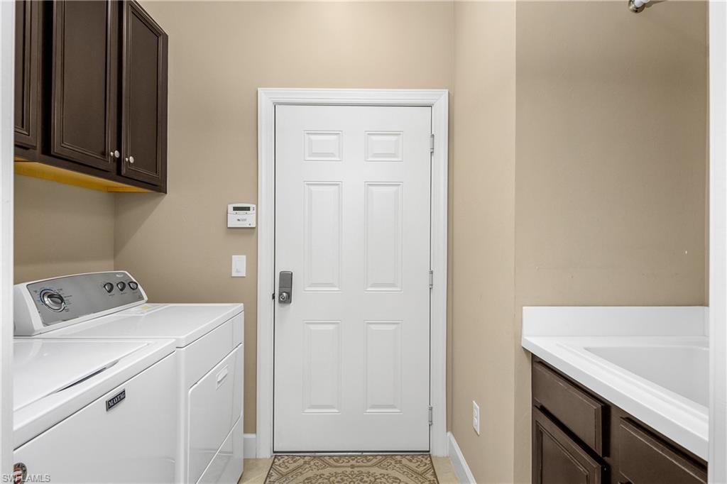 9064 Siesta Bay Drive, Unit 5102 Naples, FL 34120 - Photo 24 of 46 Laundry with utility sink and additional storage.