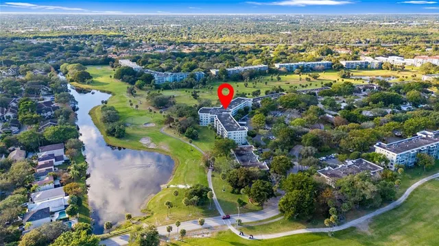 an aerial view of residential houses with outdoor space and trees