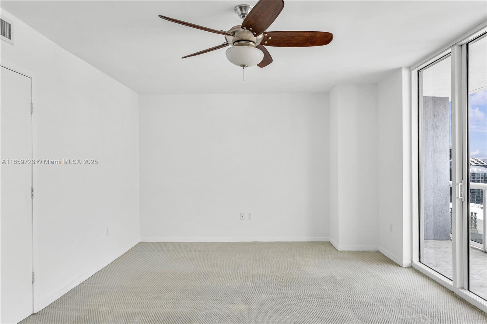 50 Biscayne Boulevard, Unit 4809 Miami, FL 33132 - Photo 6 of 11 an empty room with windows and fan