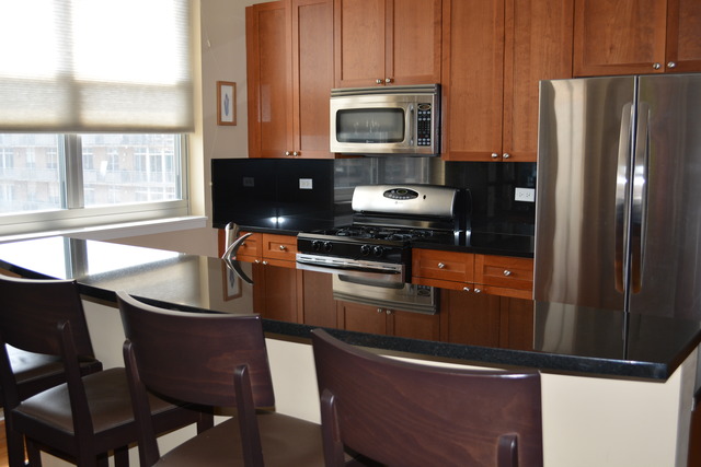 950 West Monroe Street, Unit 704 Chicago, IL 60607 - Photo 2 of 6 a kitchen with stainless steel appliances granite countertop a refrigerator stove and microwave