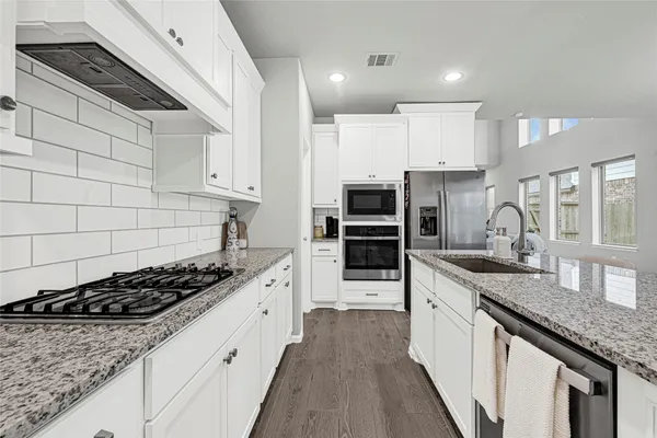 a kitchen with stainless steel appliances a sink stove and cabinets