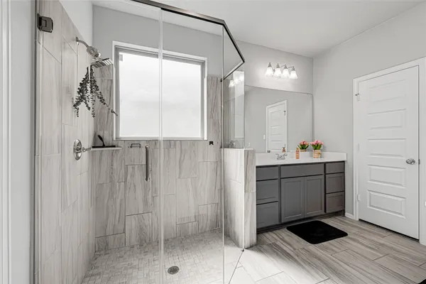 a bathroom with a shower sink and mirror