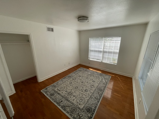 4611 Glissman Road Austin, TX 78702 - Photo 7 of 11 Hardwood floors complement this naturally illuminated bedroom with a spacious closet.