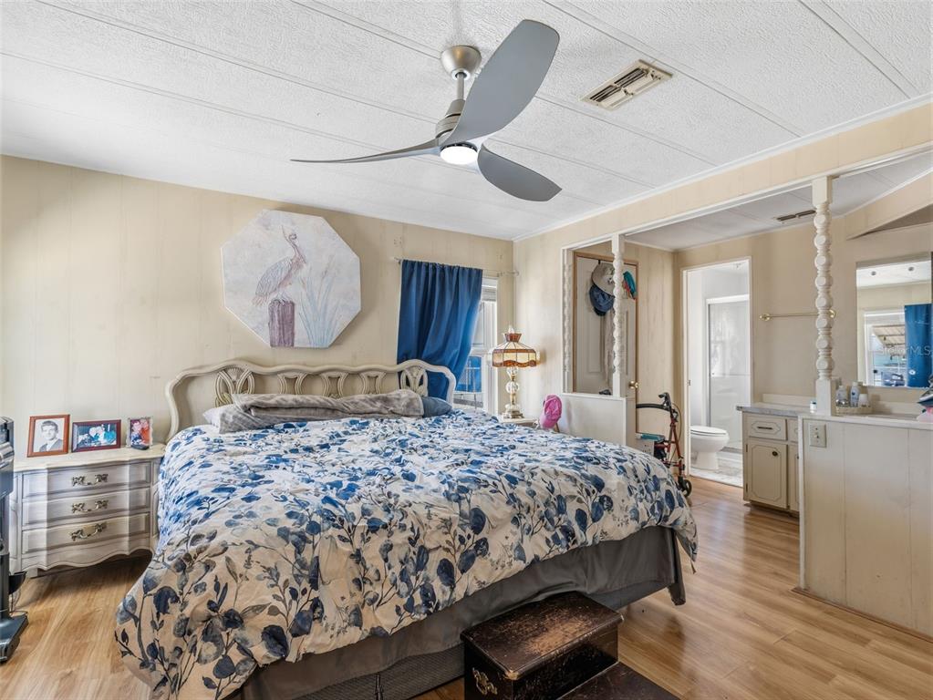 7402 Cascade Drive Hudson, FL 34667 - Photo 16 of 31 a bedroom with a bed a dresser and wooden floor
