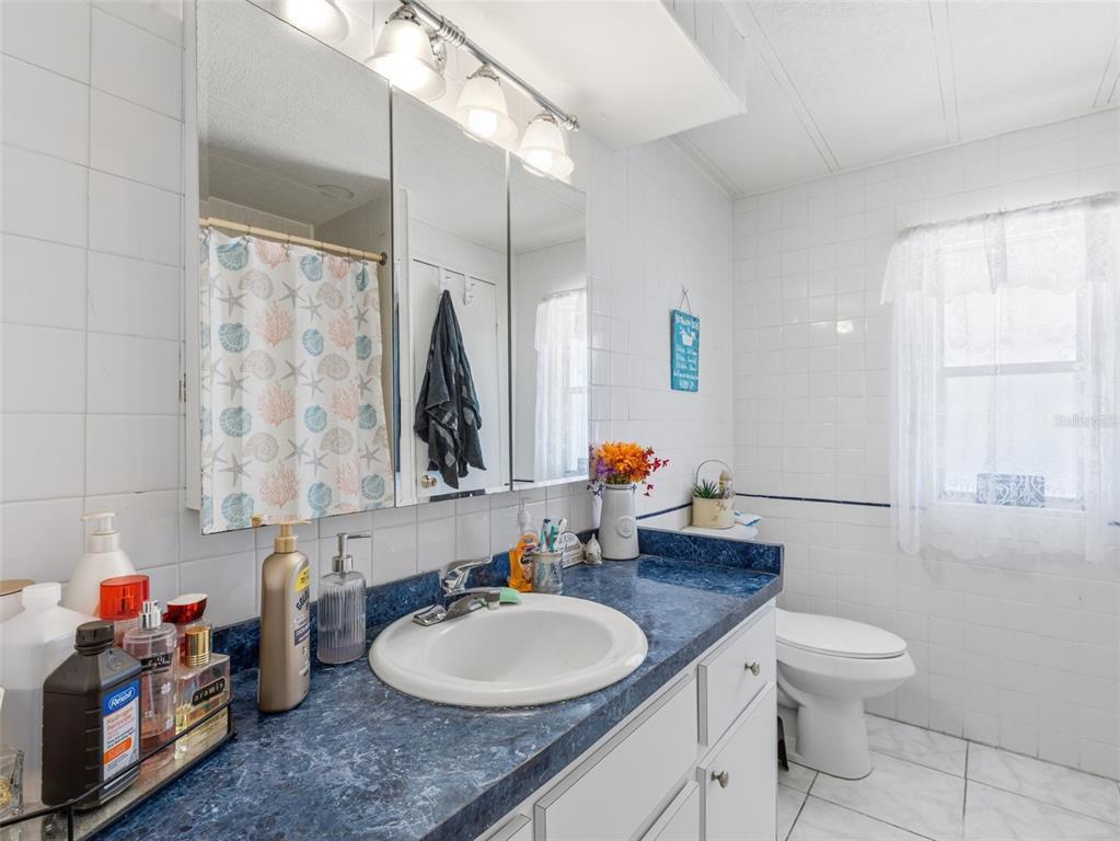 7402 Cascade Drive Hudson, FL 34667 - Photo 21 of 31 a bathroom with a granite countertop sink mirror vanity and toilet