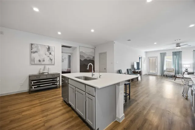 a kitchen with a sink cabinets and wooden floor