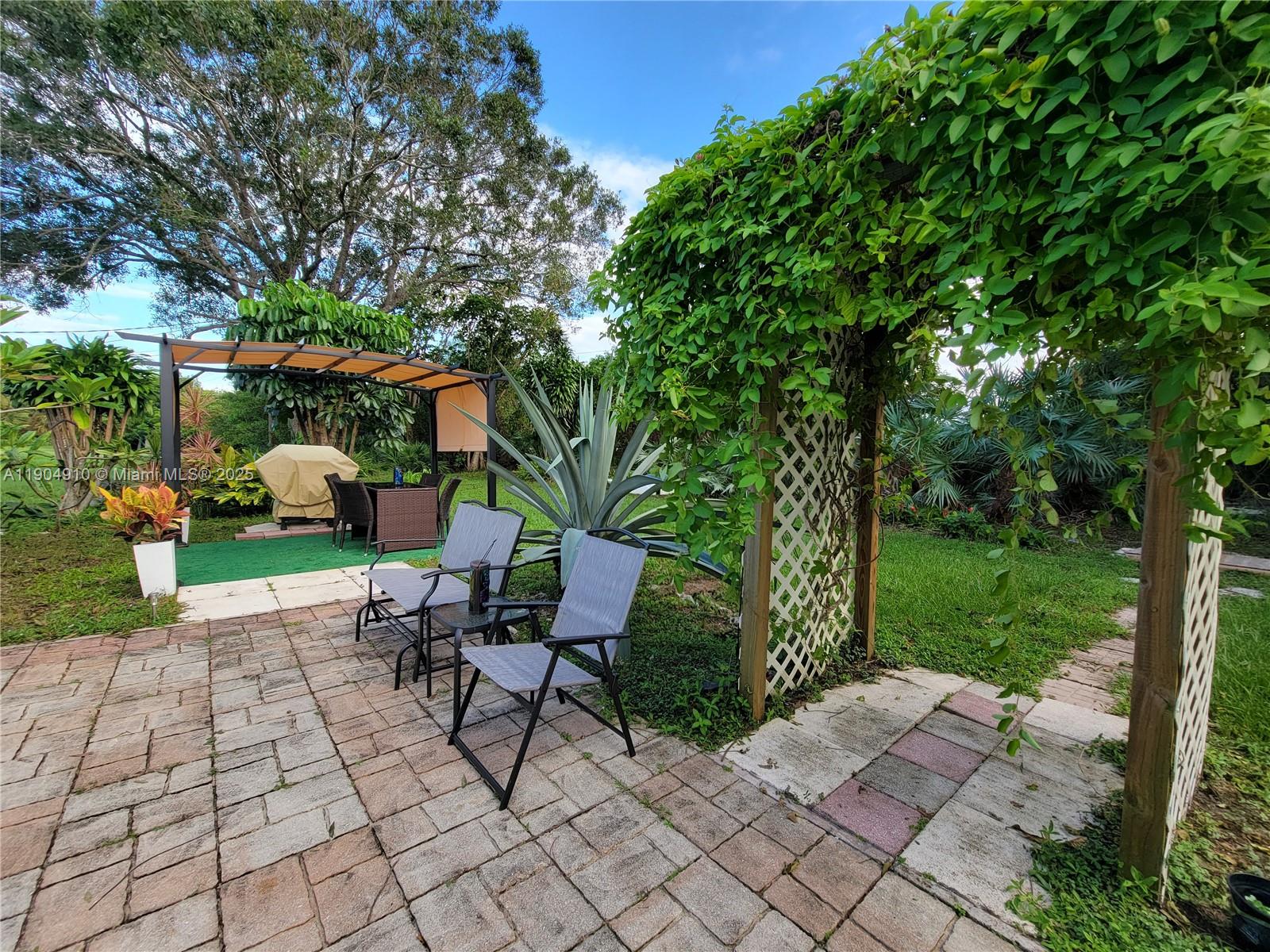 210 Banyan Drive Port St. Lucie, FL 34952 - Photo 20 of 22 a chair and table sitting in backyard of house