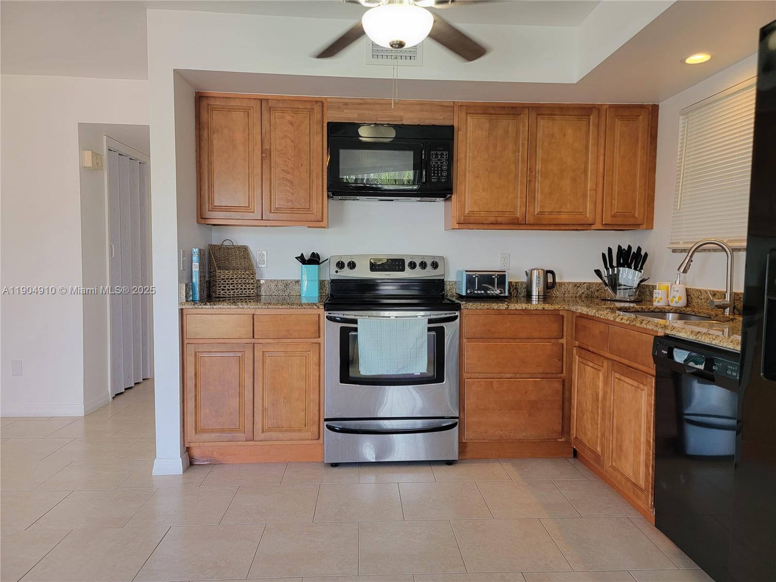 210 Banyan Drive Port St. Lucie, FL 34952 - Photo 6 of 22 a kitchen with stainless steel appliances granite countertop a stove a sink dishwasher and a microwave oven with cabinets