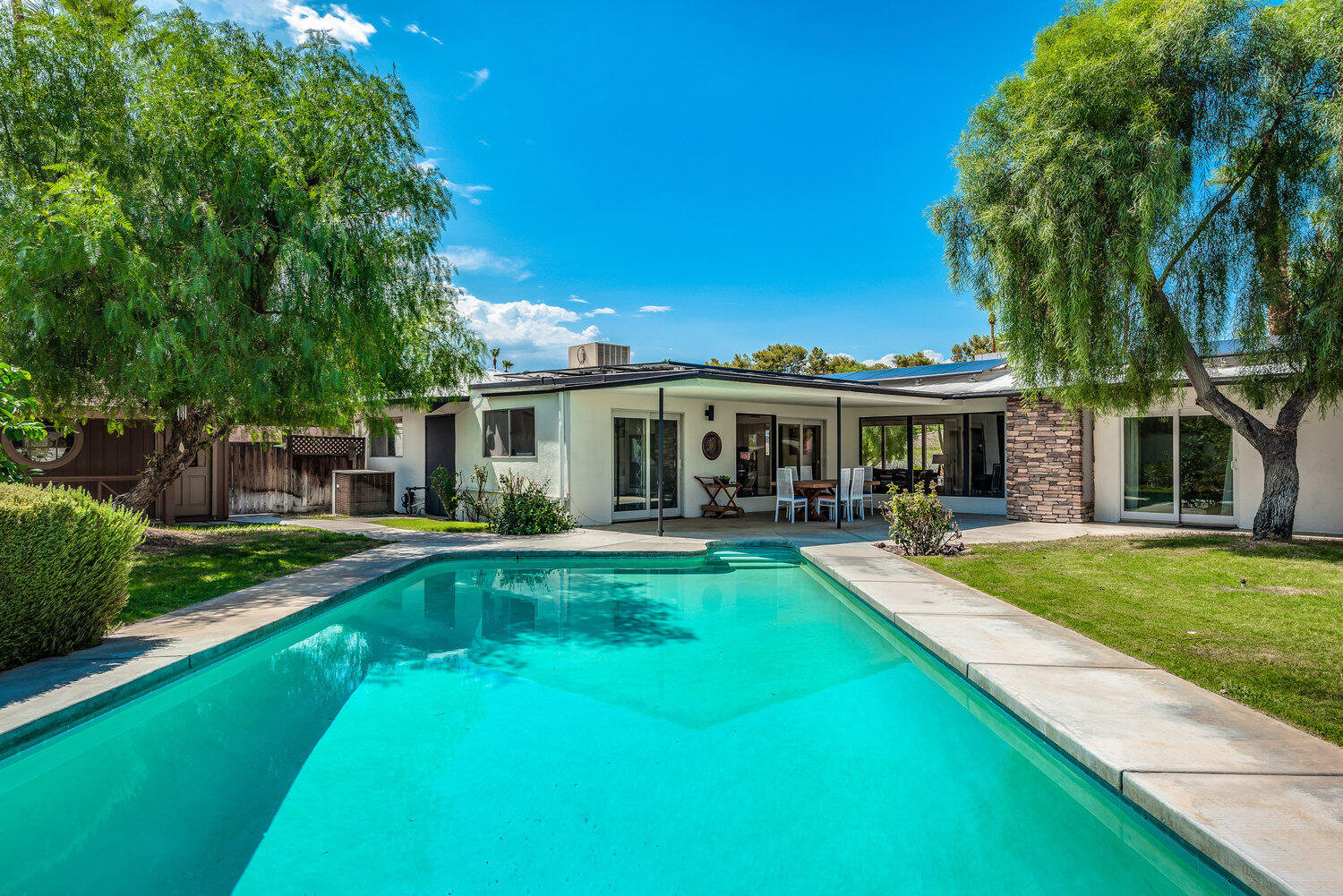 74111 Setting Sun Trail Palm Desert, CA 92260 - Photo 4 of 30 a view of a house with swimming pool and a yard