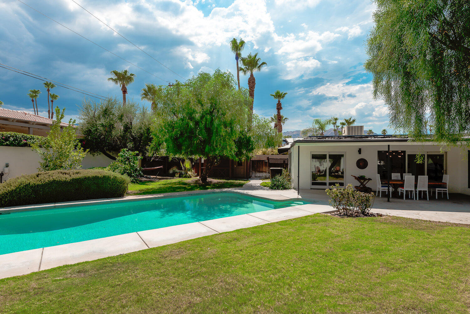 74111 Setting Sun Trail Palm Desert, CA 92260 - Photo 6 of 30 a front view of a house with garden and sitting area