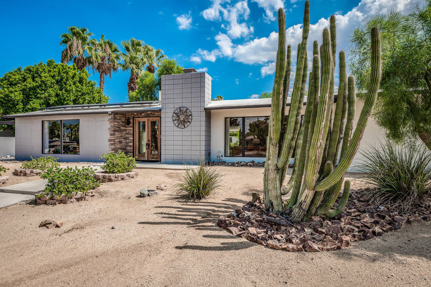 74111 Setting Sun Trail Palm Desert, CA 92260 - Photo 7 of 30 a front view of a house with a yard and potted plants