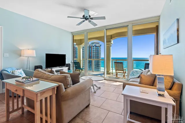 a living room with furniture a flat screen tv and a large window