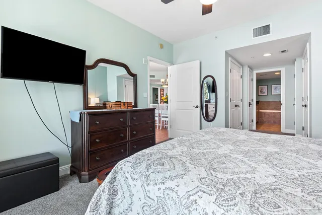 a bedroom with a bed and a flat tv screen on dresser