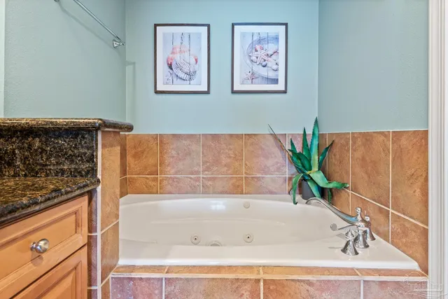 a bathroom with a bathtub and a potted plant
